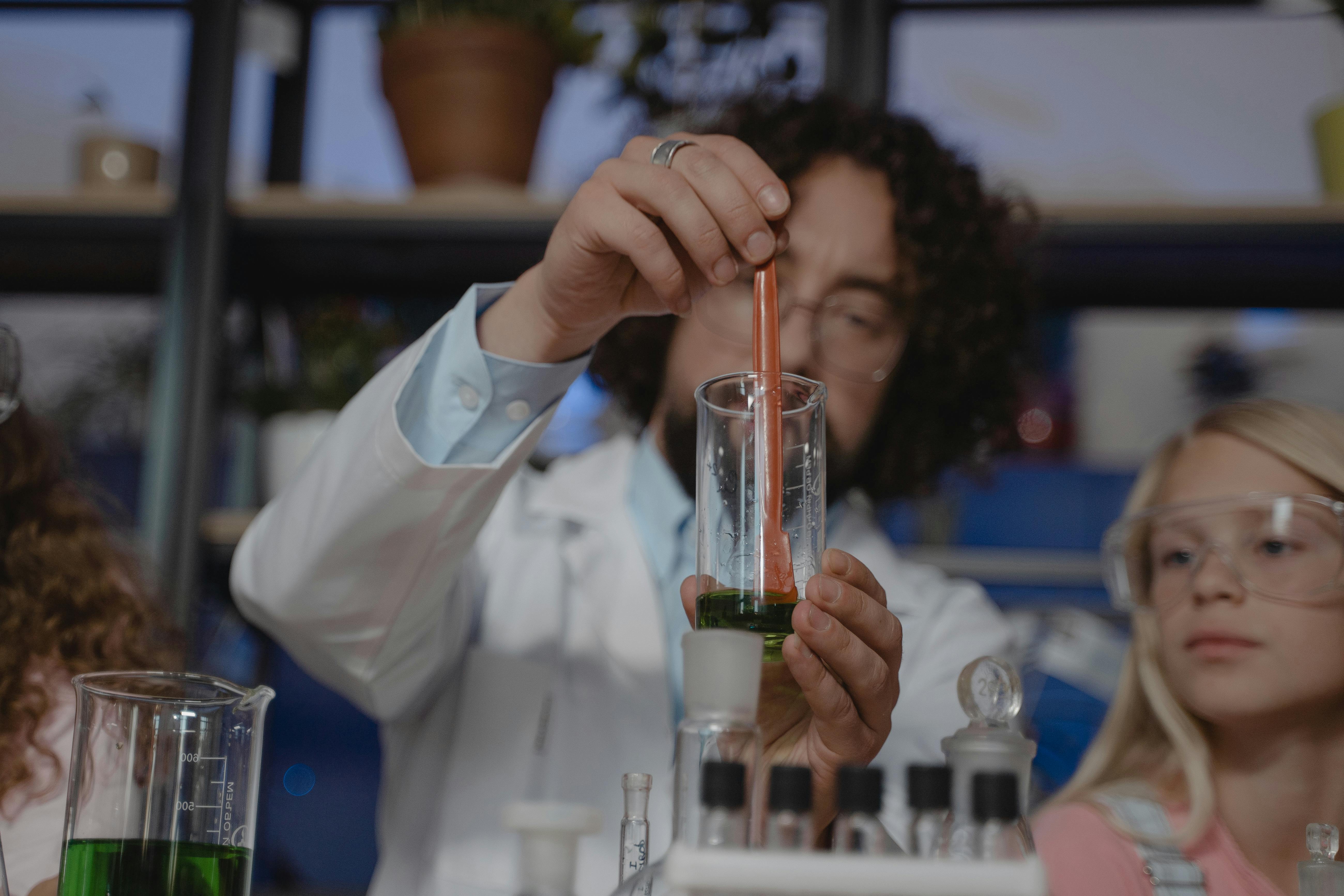 Engaging chemistry class with a teacher and students conducting a science experiment with beakers and test tubes.